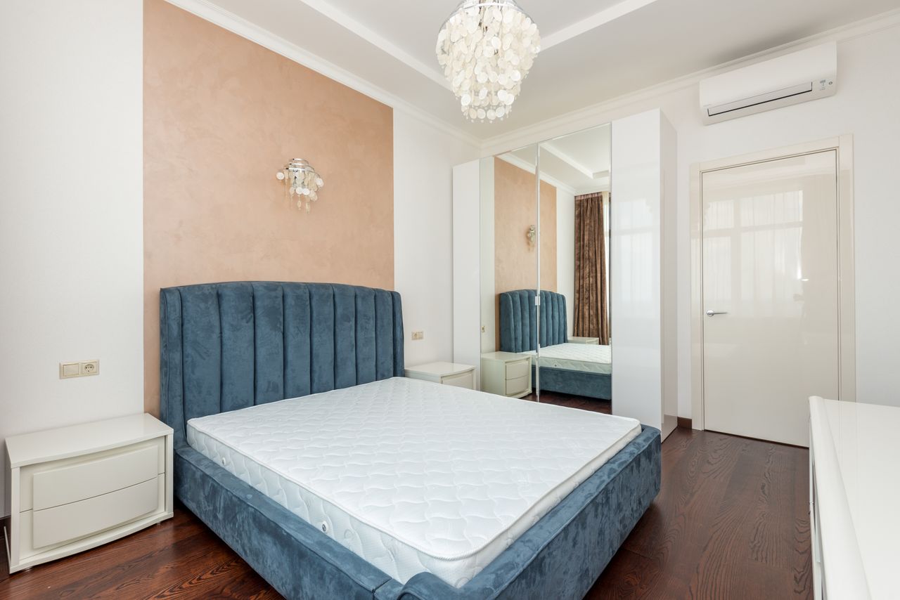 Home Elegant bedroom featuring a plush blue velvet bed and chic pendant light.
