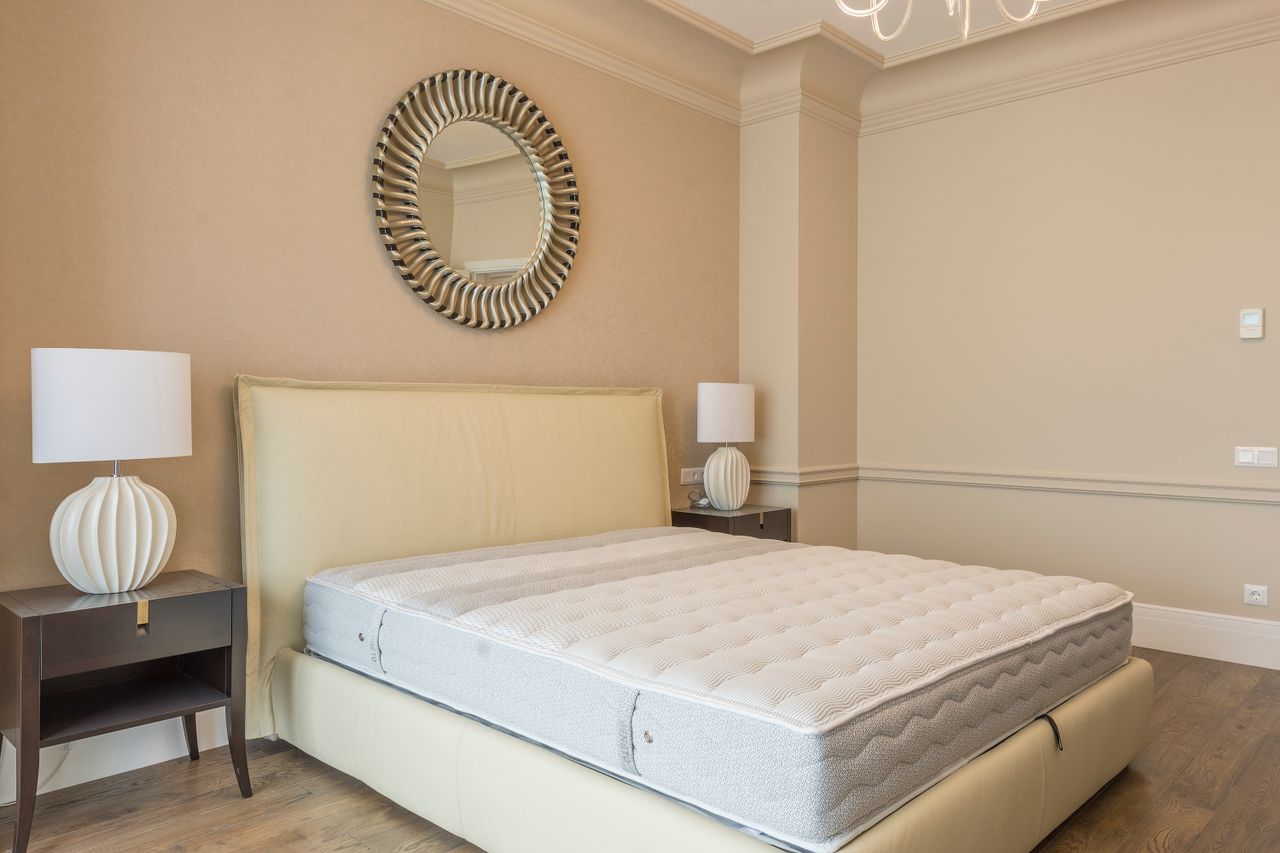 Home Spacious bedroom featuring modern decor, elegant lighting, and a plush bed with neutral tones.